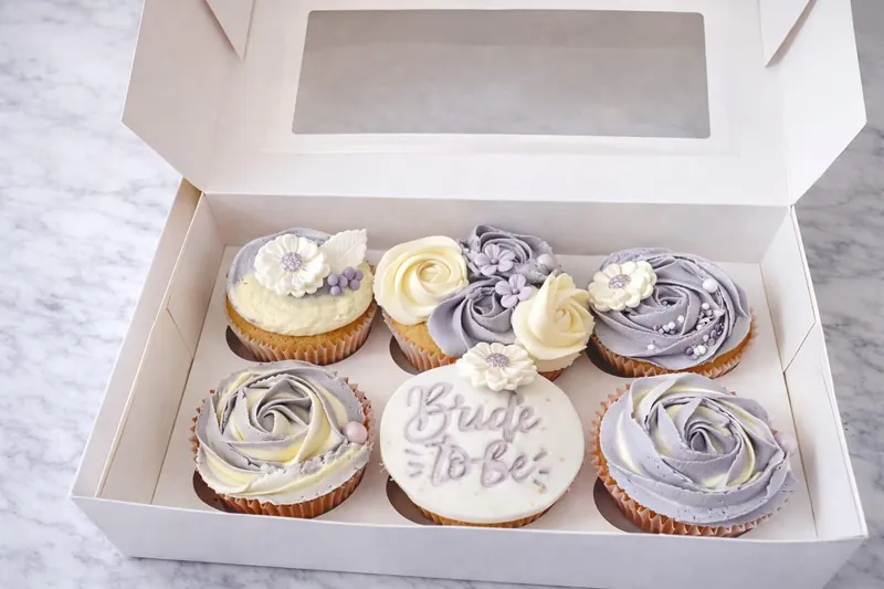 Lilac and cream cupcakes with sugar daisies and a Bride to Be topper